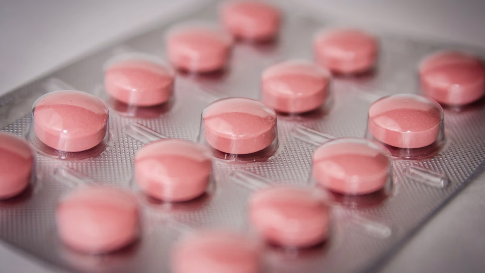 Compresse rosa in un blister, che enfatizzano i concetti di assistenza sanitaria e medicazione. — Pixabay – Pexels