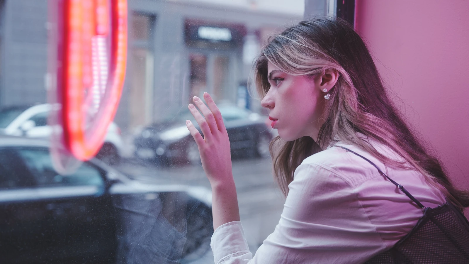 Donna contemplativa che guarda fuori dalla finestra di un caffè nel paesaggio urbano di Berlino.