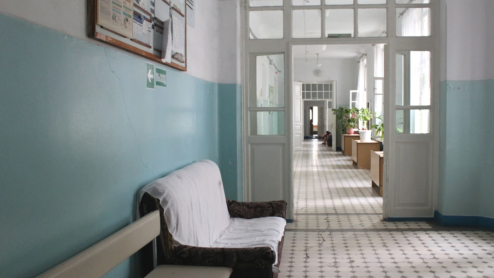 Un corridoio vuoto di ospedale vintage con mobili classici e piante in vaso a Ukrainka.
