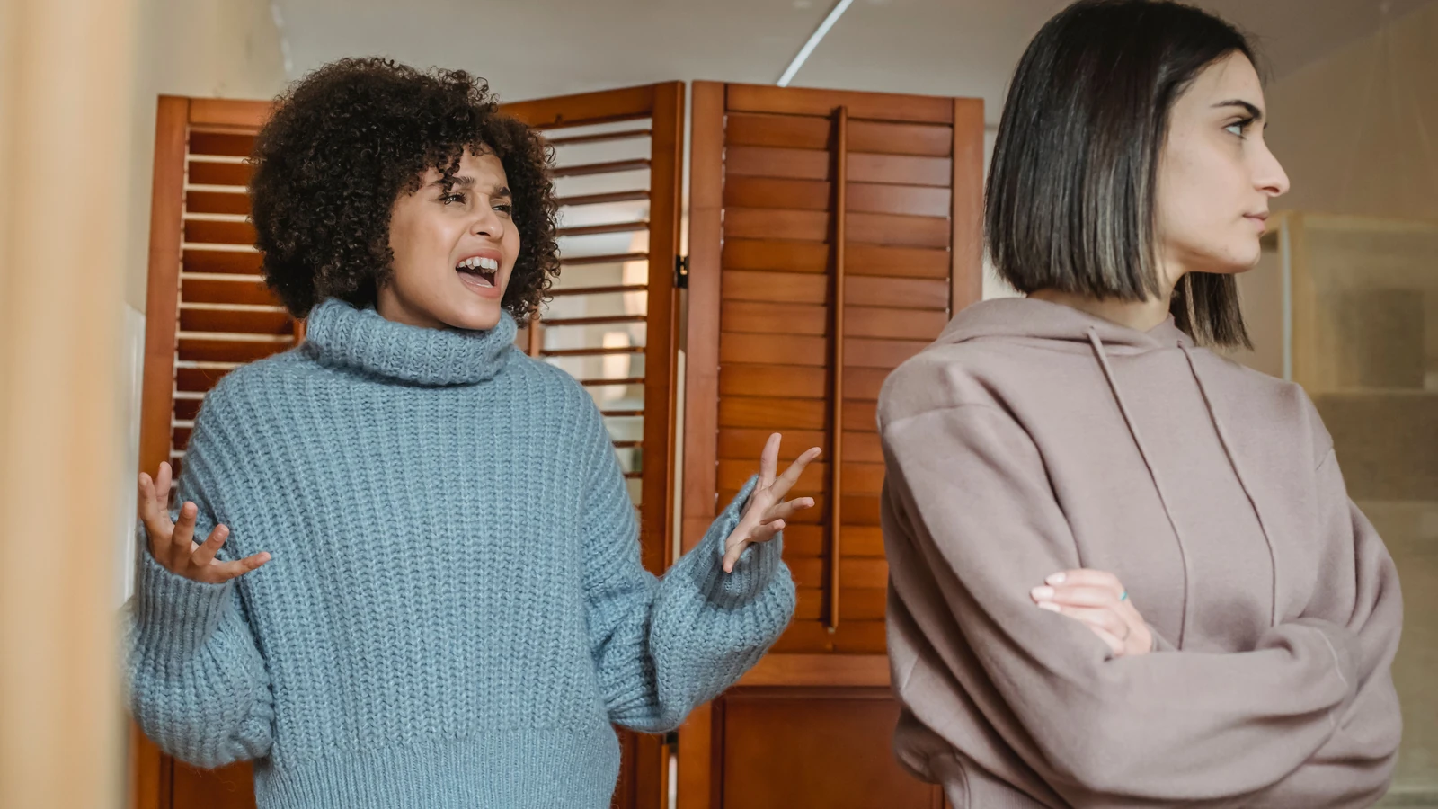 Due donne che esprimono frustrazione e disaccordo durante una discussione all'interno di una stanza. — Liza Summer – Pexels