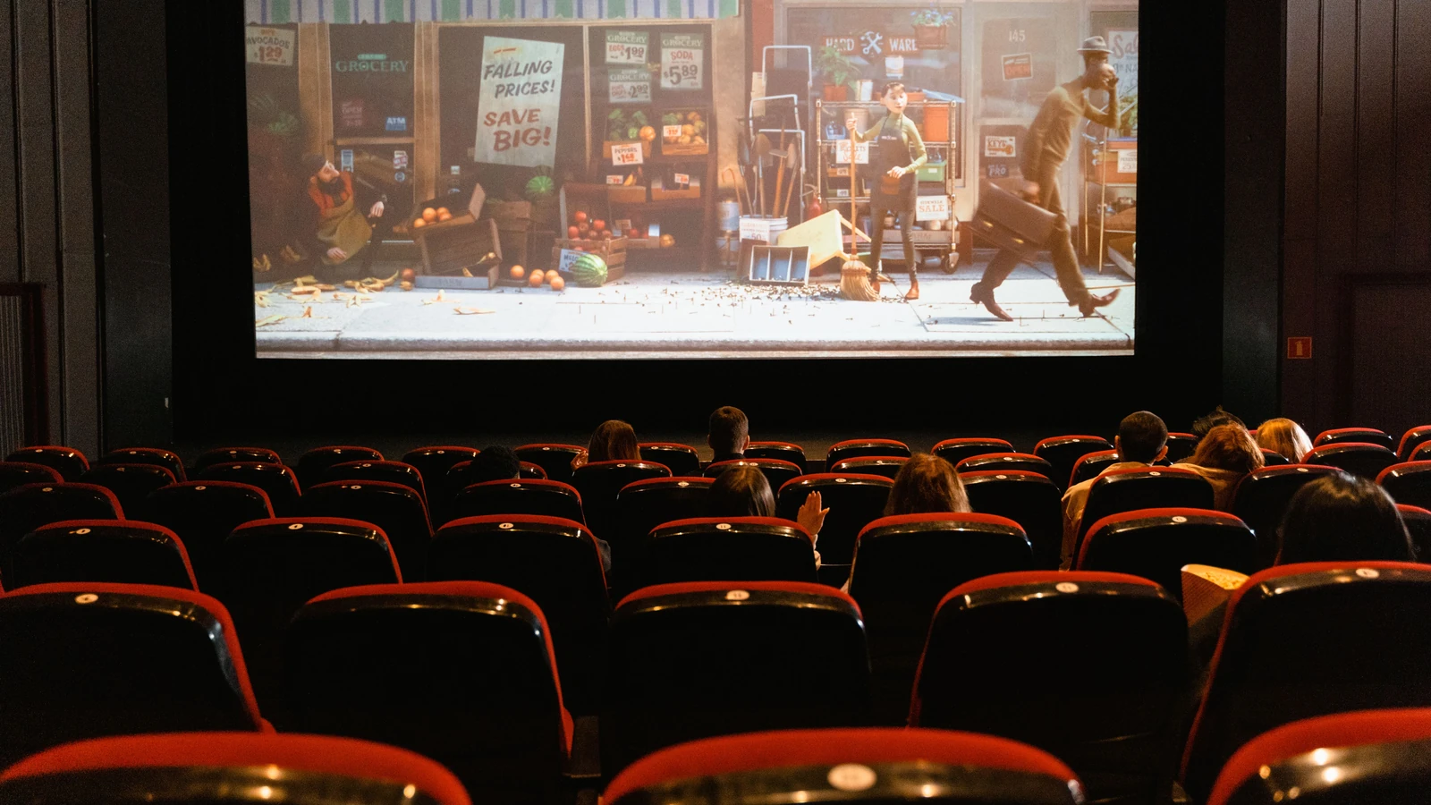 Un accogliente cinema al chiuso che proietta un film animato a un piccolo pubblico.