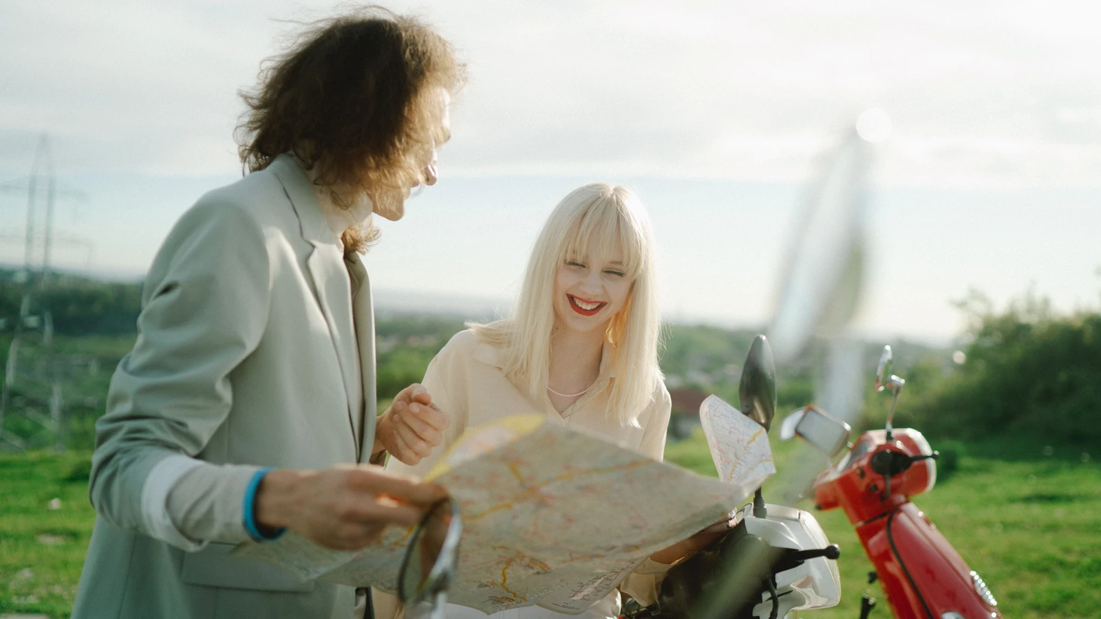 Felice coppia che esplora con una mappa in una giornata di sole, pianificando il loro viaggio con entusiasmo.