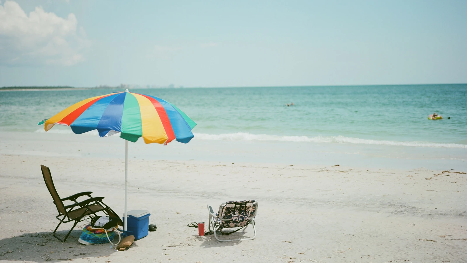 Una vivace scena di spiaggia a Clearwater, FL, con un ombrellone colorato e lettini.