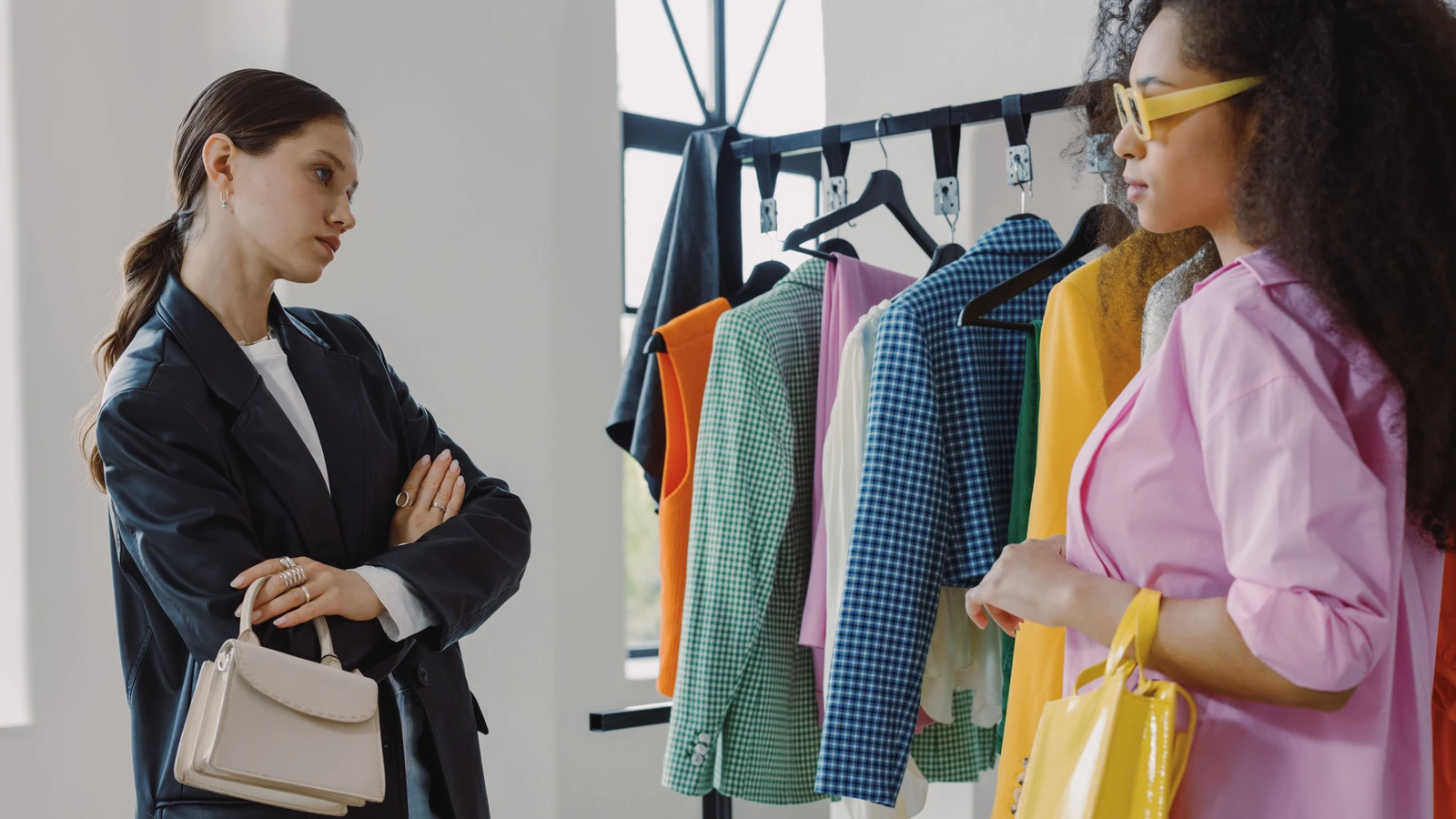 Due donne che sfogliano stand di abbigliamento colorato in una boutique moderna.