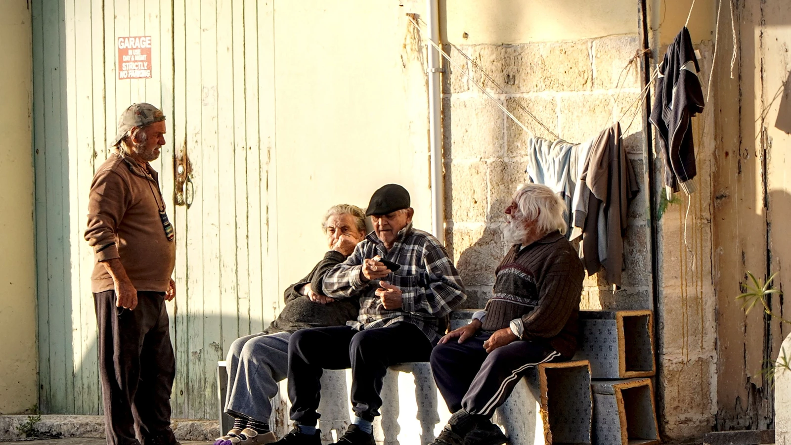A Malta gli anziani si rilassano all'aria aperta, incarnando la lentezza e il piacere di vivere in un ambiente soleggiato.