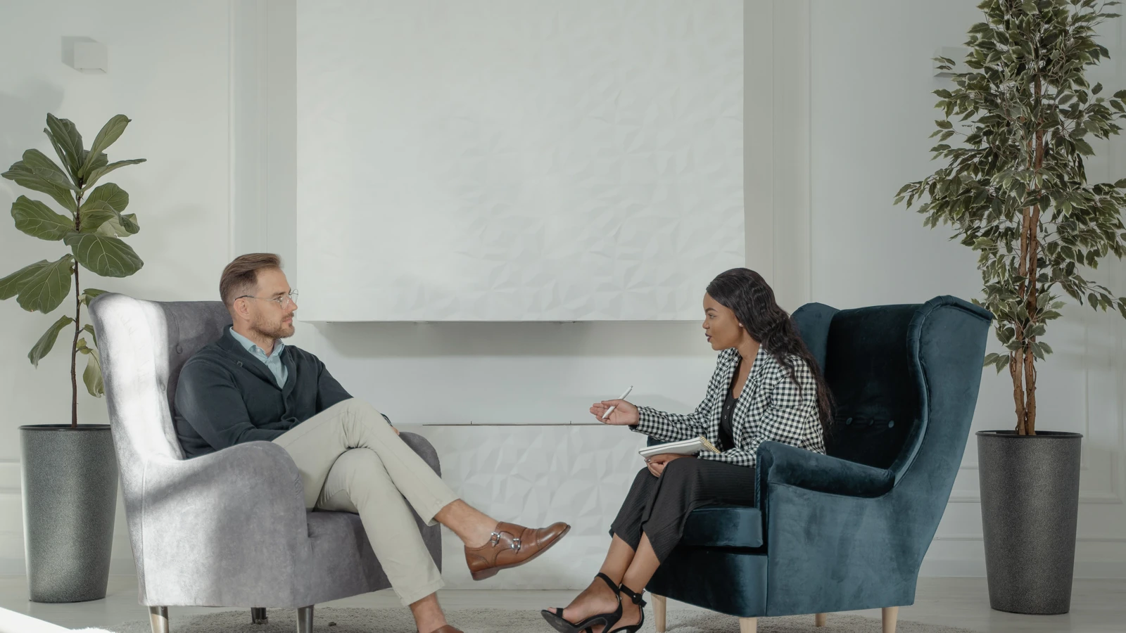 Una terapeuta e paziente impegnate in una conversazione in un moderno e elegante studio di terapia.