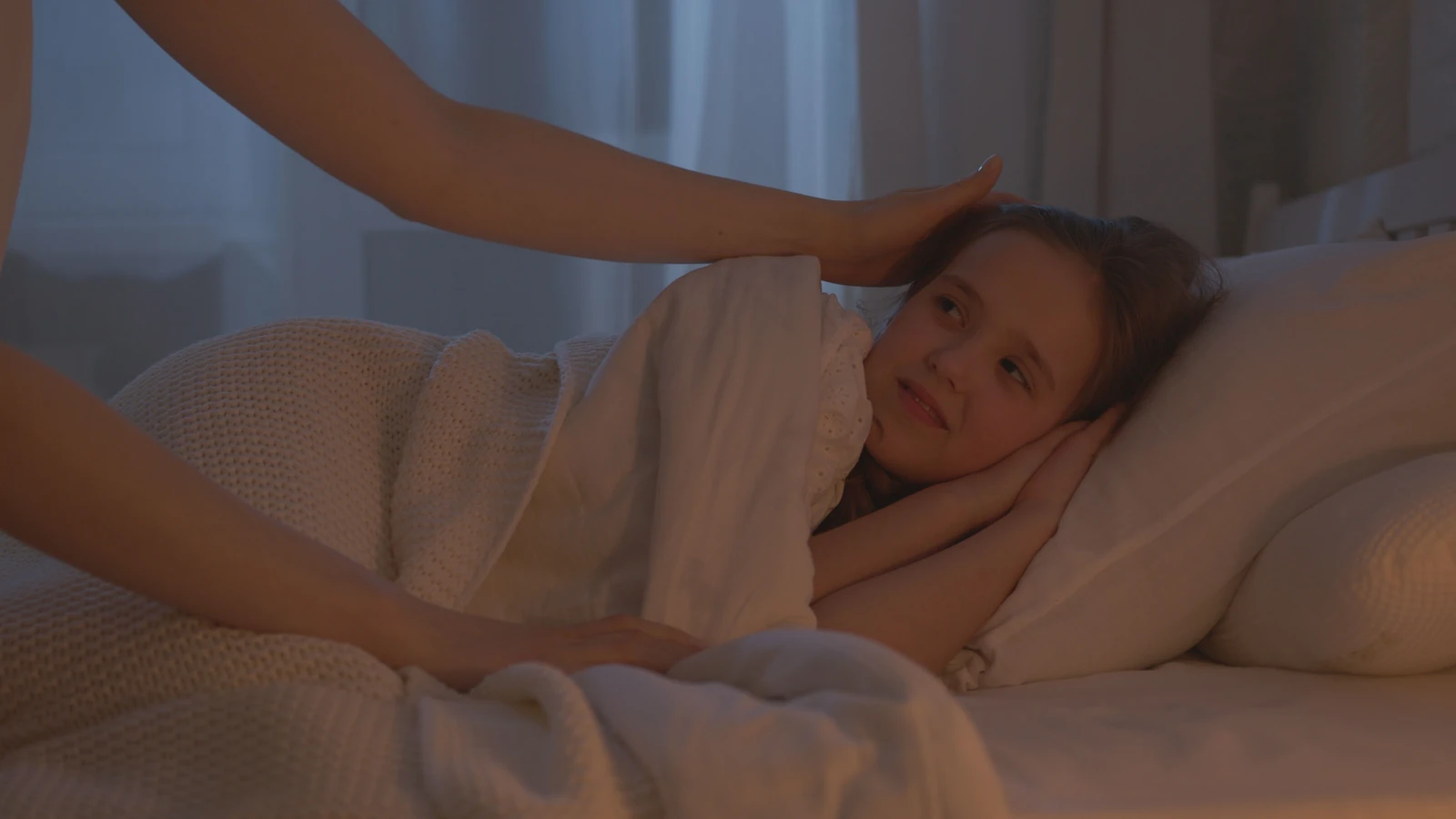 Una scena confortante di un adulto che mette a letto un bambino, creando un'atmosfera calda e pacifica per la buonanotte.