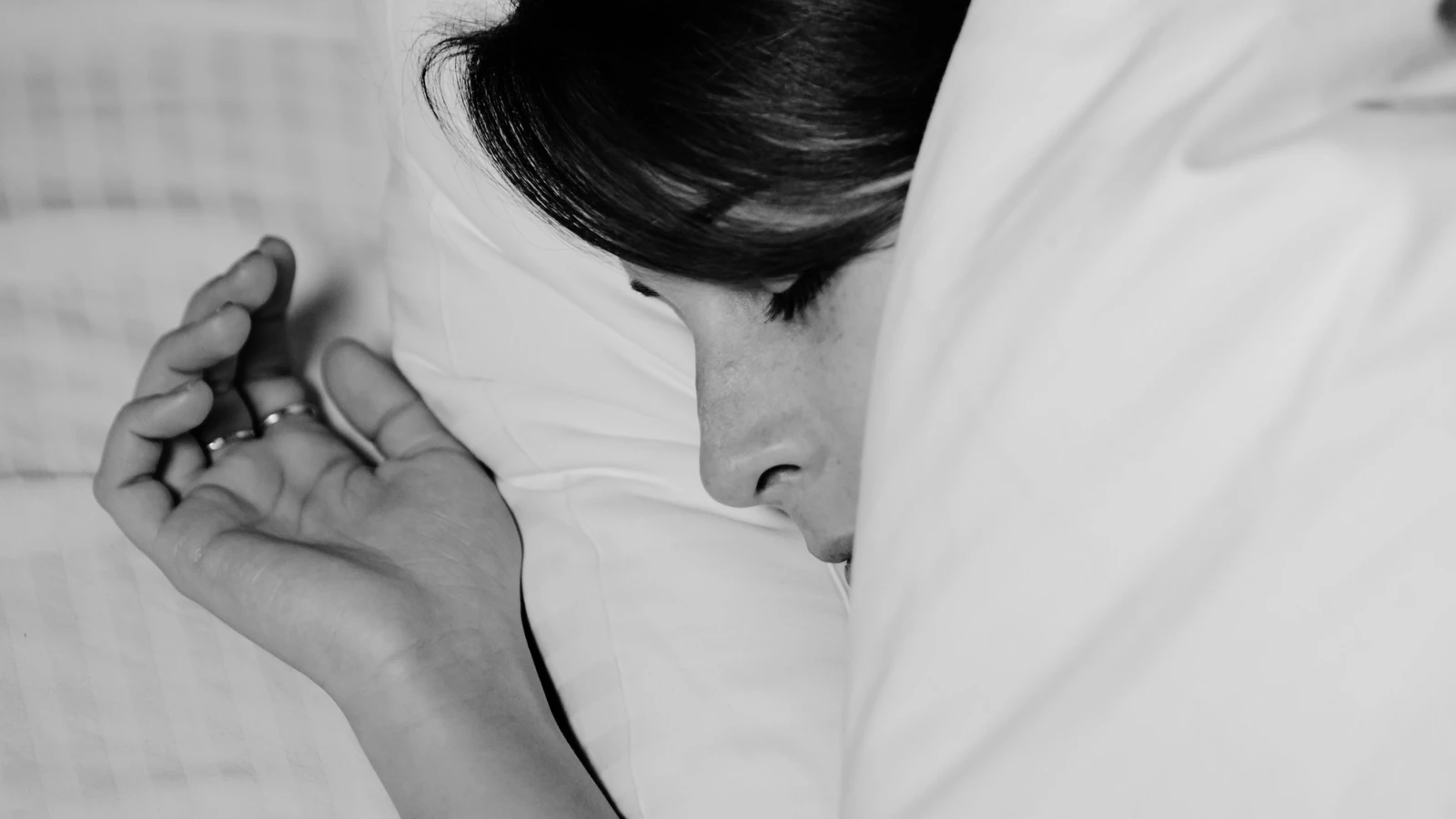 Primo piano di una persona che dorme pacificamente, catturata in bianco e nero per un'atmosfera serena.