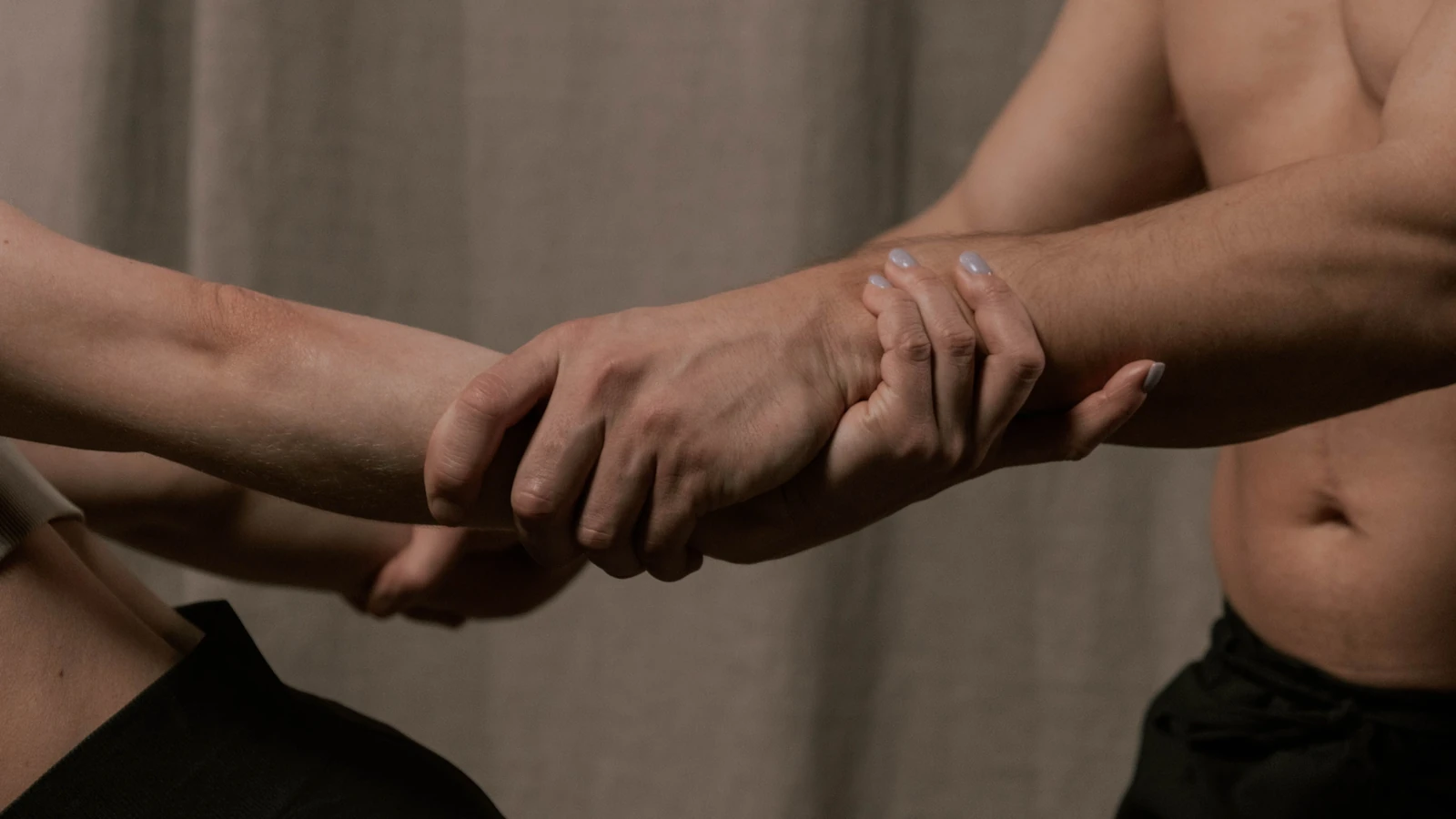 Un'immagine ravvicinata di una posa di yoga con partner che si allungano al chiuso, enfatizzando il lavoro di squadra e la flessibilità.