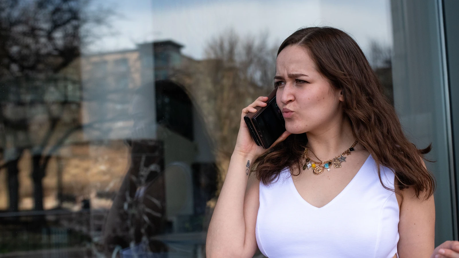 Una donna esprime la sua frustrazione durante una telefonata mentre si trova all'aperto in pieno giorno. — Andrew Patrick Photo – Pexels