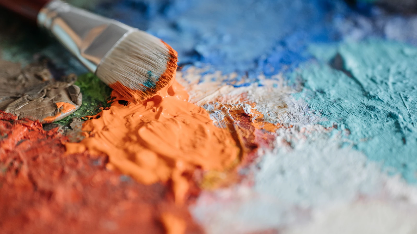 Un primo piano dettagliato di un pennello che mischia colori vivaci su una tavolozza, mostrando la creatività artistica.