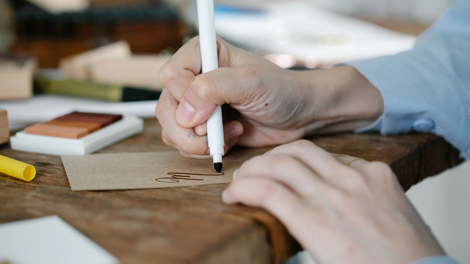 Un primo piano dettagliato di una persona che scrive a mano su un cartone con un evidenziatore, perfetto per creativi.