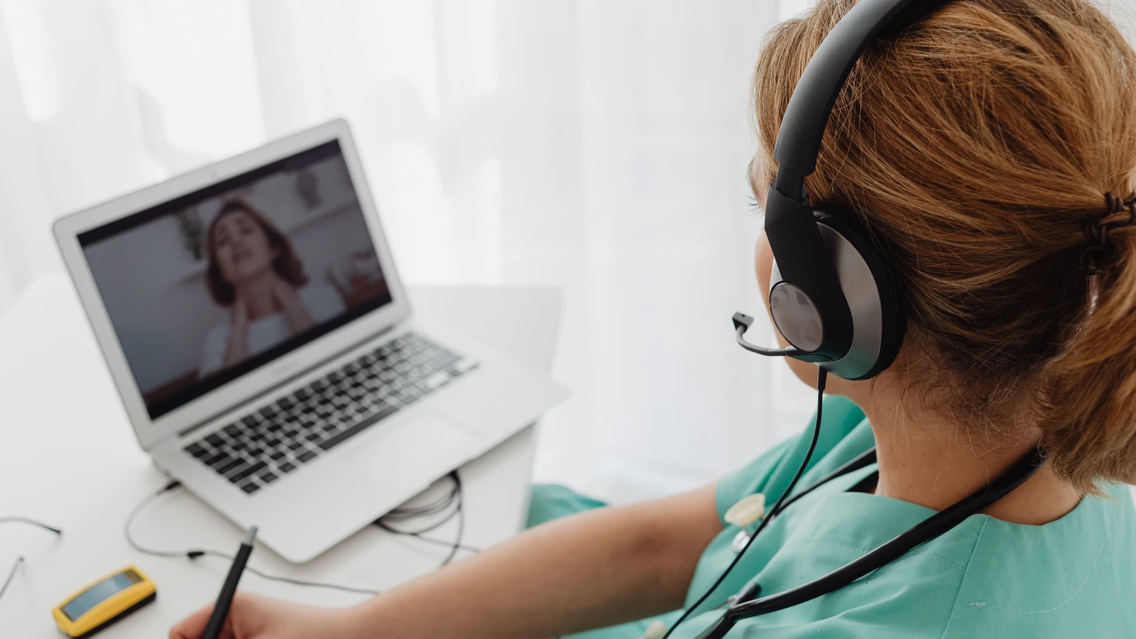 Professionista medico che consulta un paziente online tramite laptop per servizi di telemedicina.