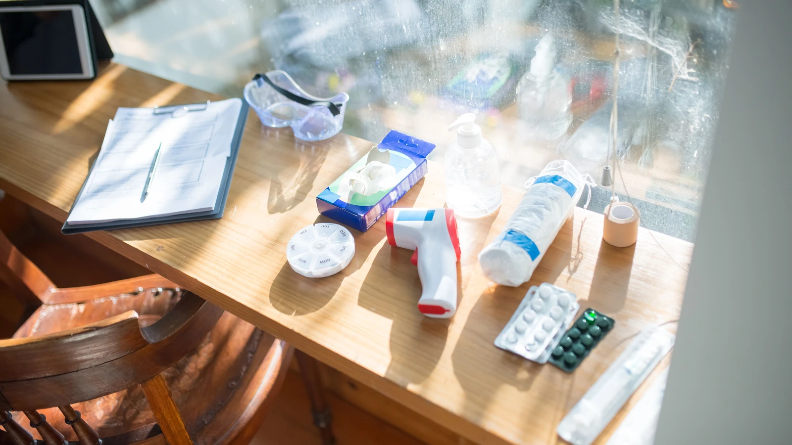 Una scrivania illuminata dal sole con forniture mediche e un clipboard, perfetta per concetti di assistenza sanitaria domiciliare. — Kampus Production – Pexels