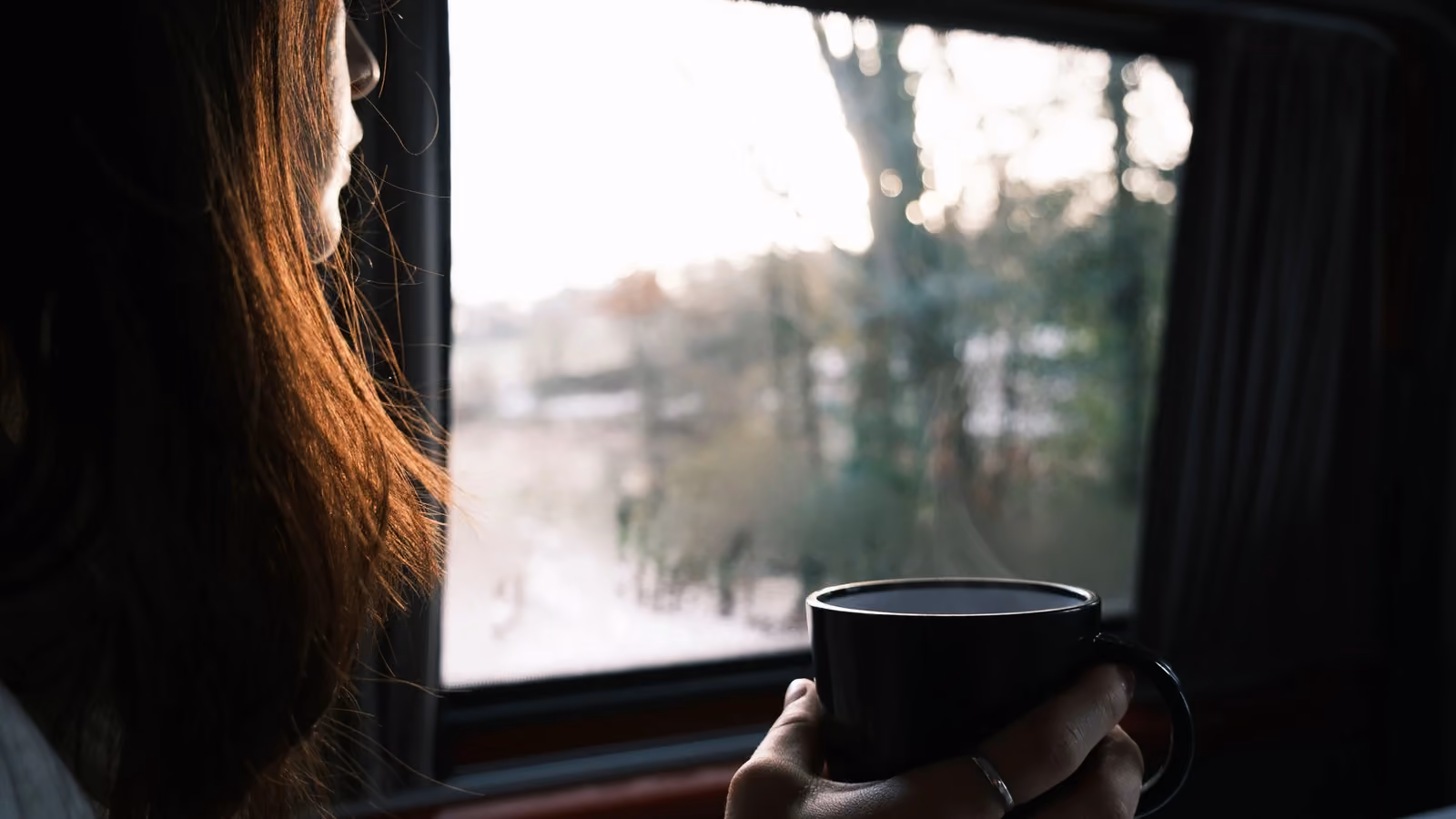 Un momento sereno catturato mentre una donna assapora il suo caffè dalla finestra, godendo della luce del mattino. — Kévin et Laurianne Langlais – Pexels