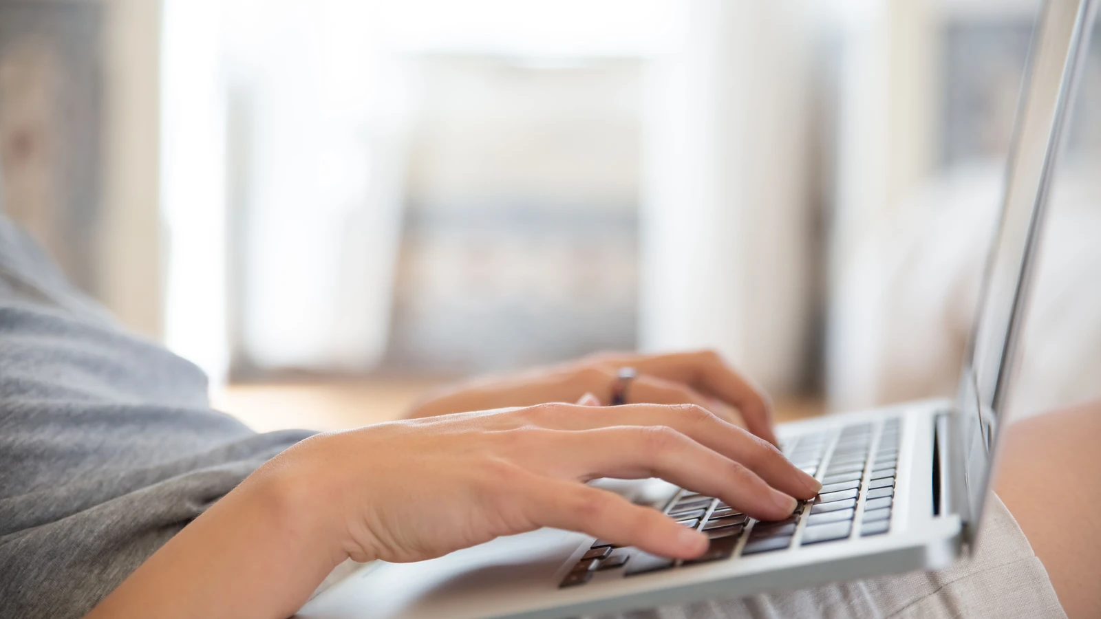 Primo piano delle mani che digitano su un laptop al chiuso, che rappresenta lo stile di vita del lavoro da remoto.