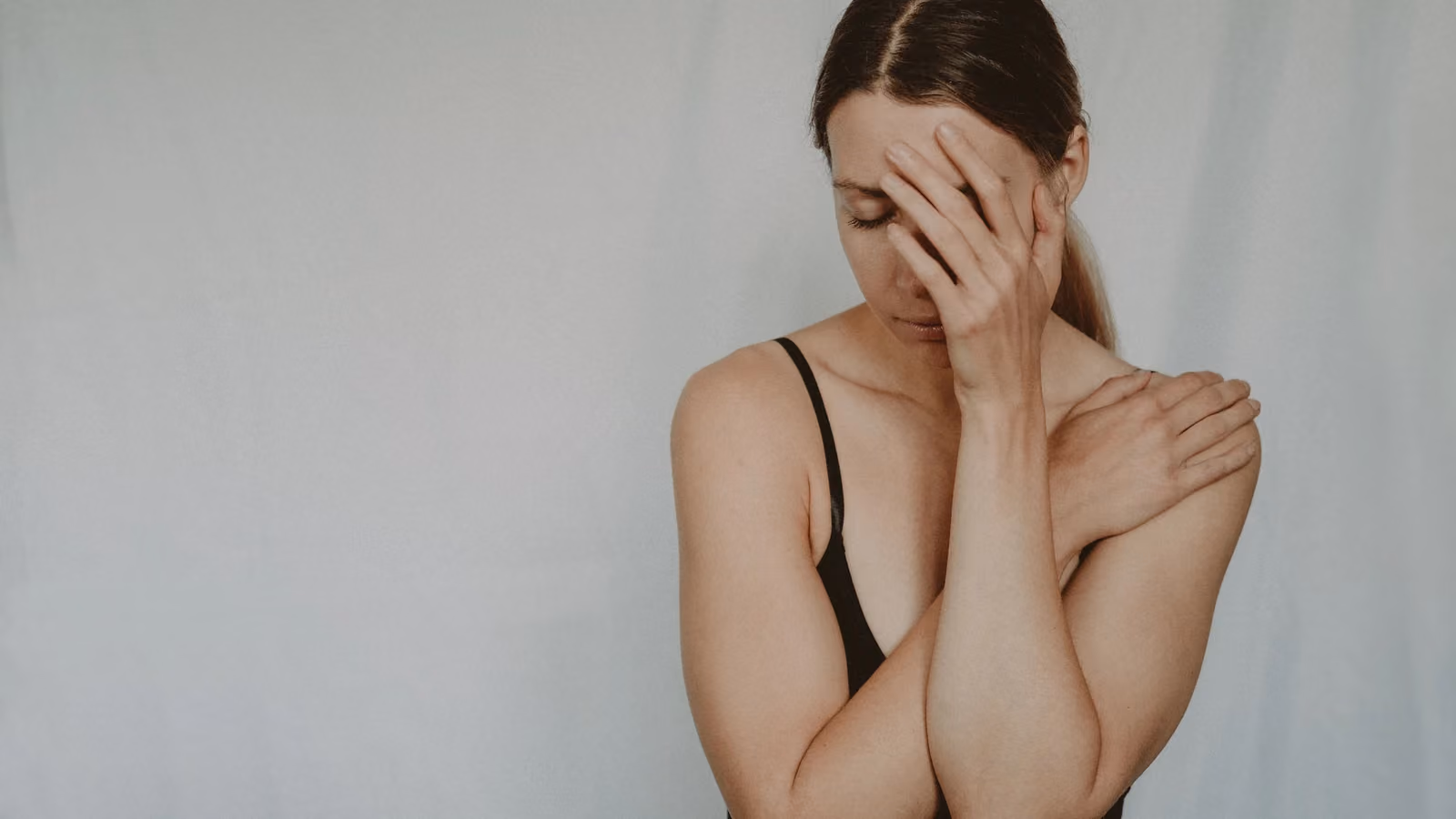 Una donna in contemplazione con una mano sul viso, che esprime disagio emotivo. — Anete Lusina – Pexels