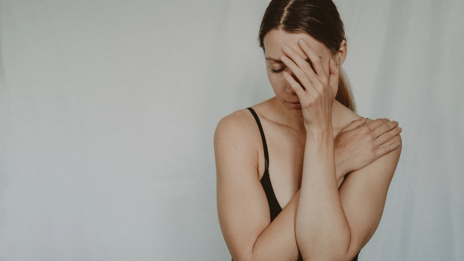 Una donna in contemplazione con una mano sul viso, che esprime disagio emotivo. — Anete Lusina – Pexels