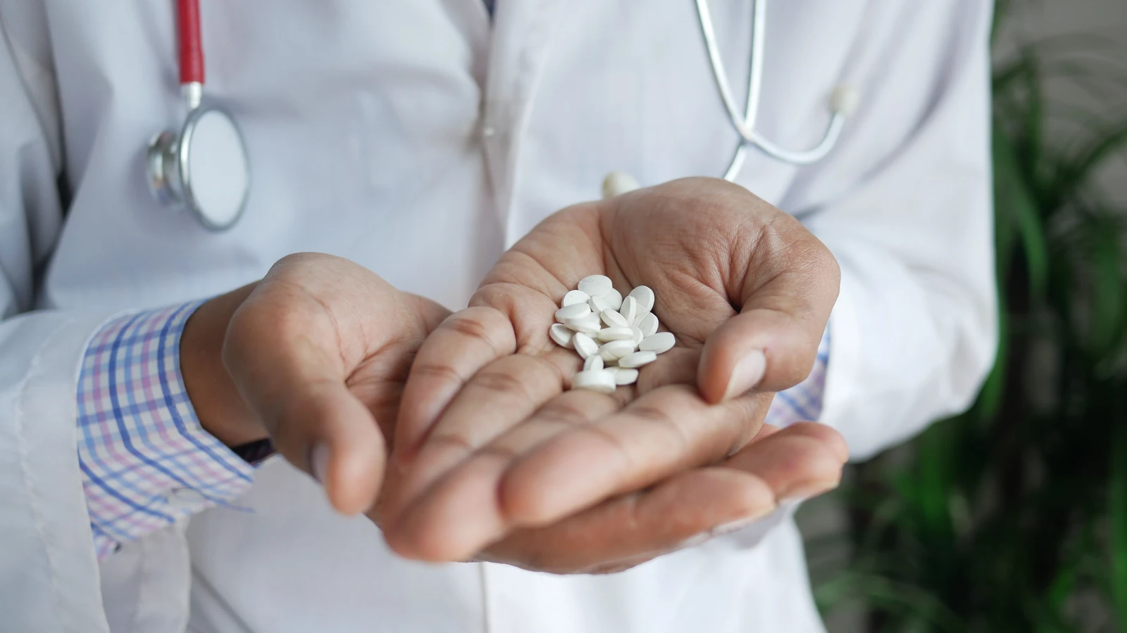 Un primo piano di un medico che tiene pillole bianche tra le mani, sottolineando l'assistenza sanitaria e la medicina. — Towfiqu barbhuiya – Pexels