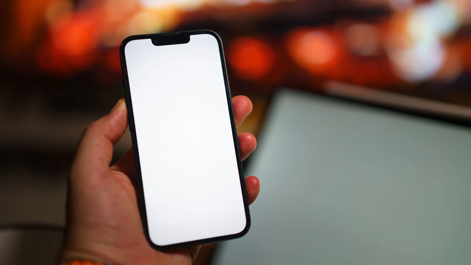 Schermo vuoto di uno smartphone tenuto in mano in un ambiente interno caldo e accogliente, ideale per mock-up — Jakub Zerdzicki – Pexels