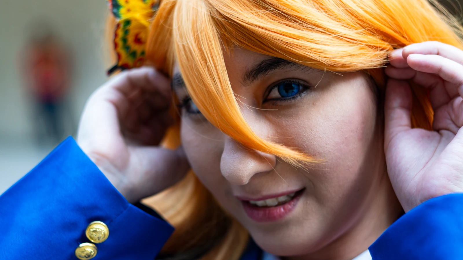 Primo piano di una persona in costume cosplay colorato con accento di farfalla vivace, che sorride all'aperto. — Vintage Lenses – Pexels