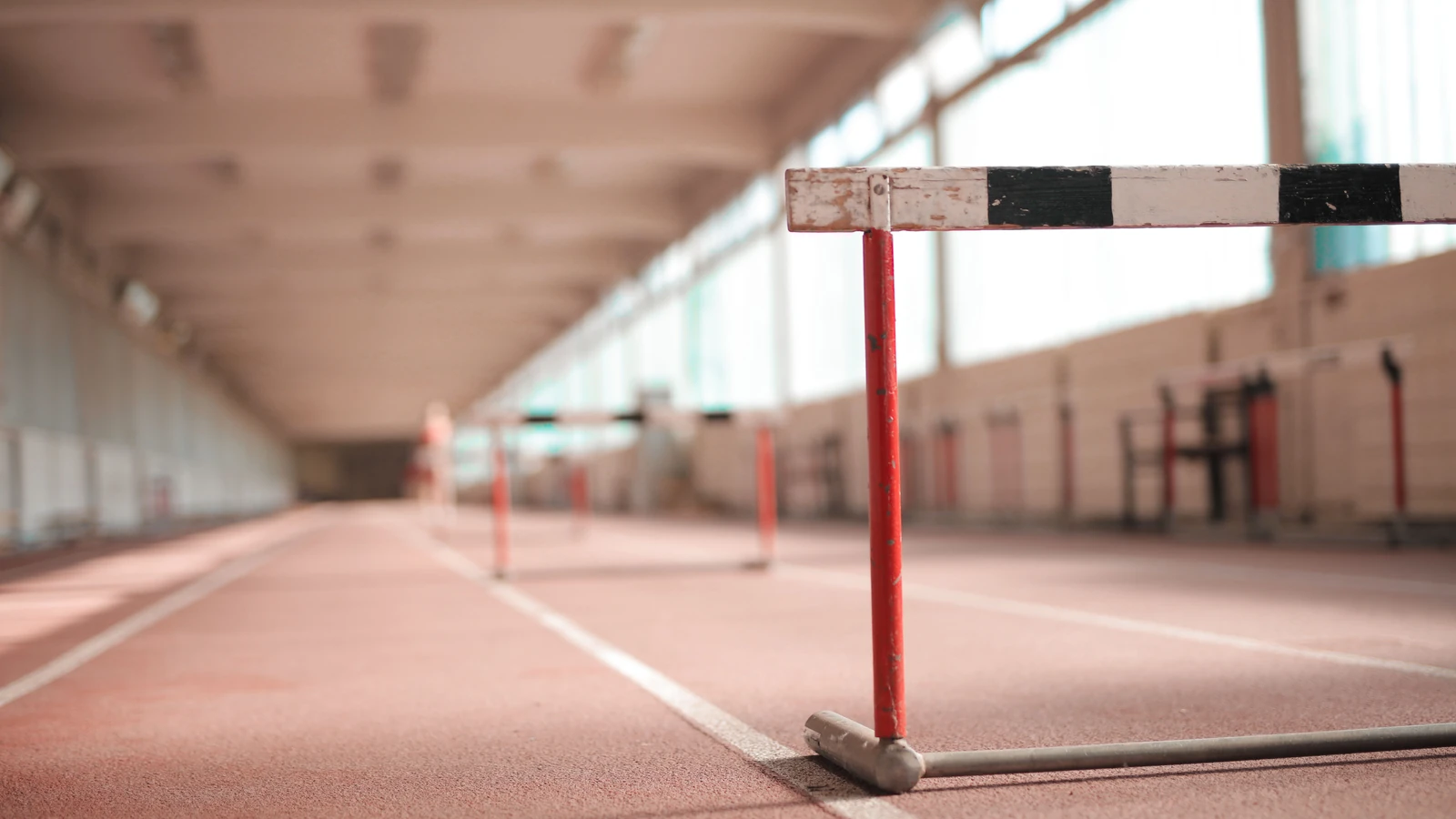 Pista di atletica indoor vuota con ostacoli per sessioni di allenamento.