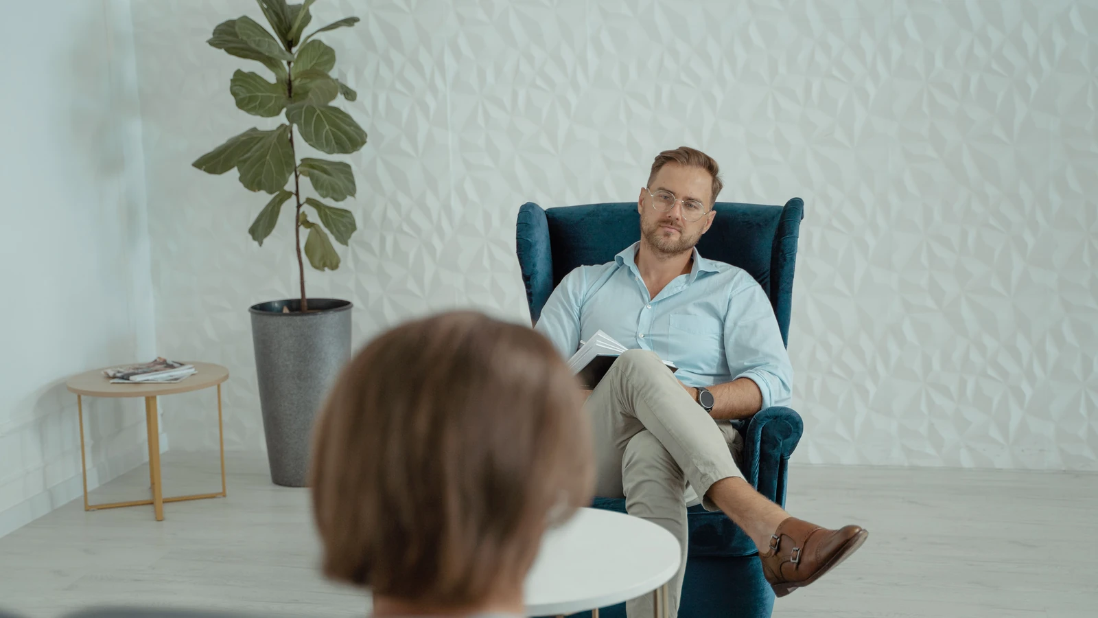 Una sessione di consulenza con un uomo seduto su una sedia comoda all'interno.