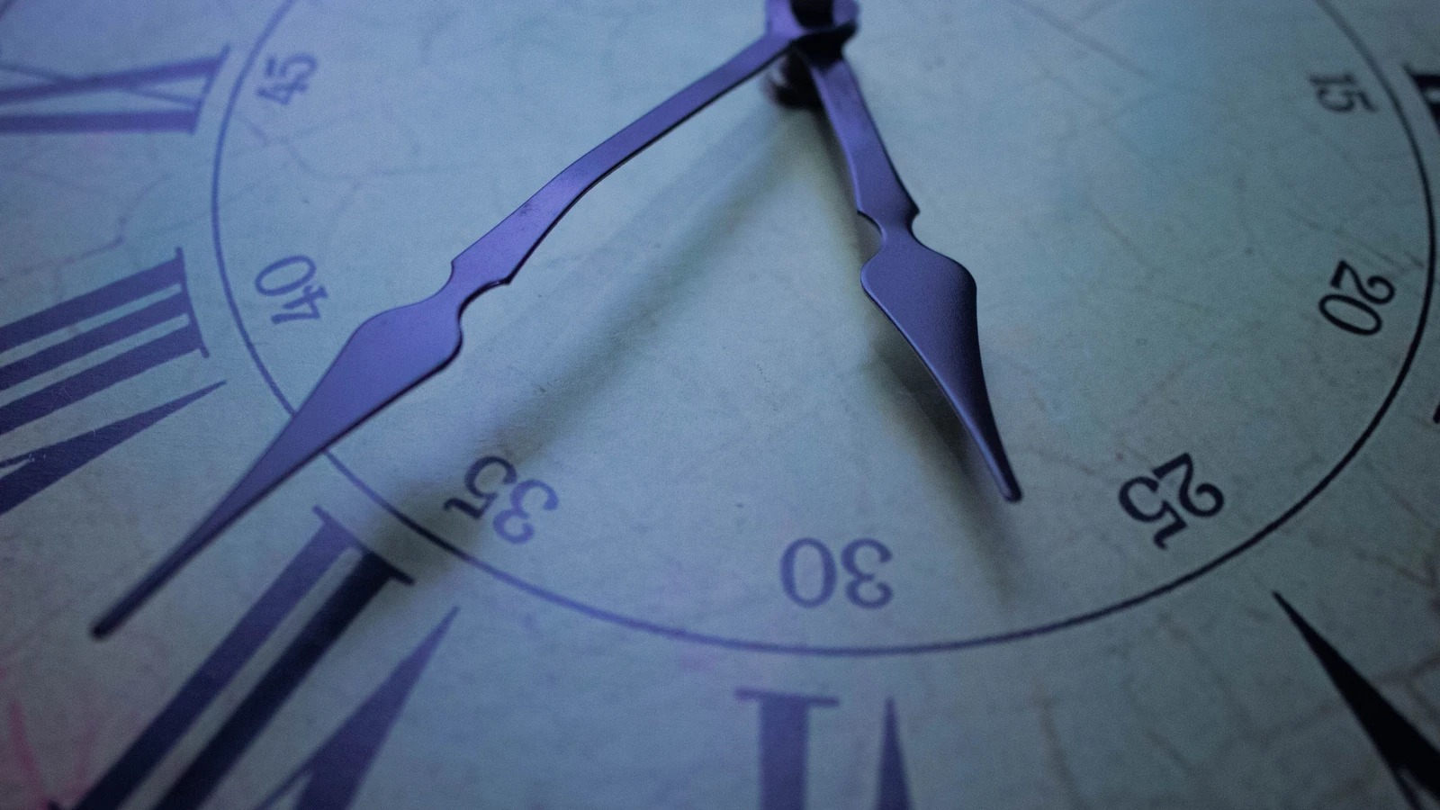 Dettaglio in primo piano di un quadrante di orologio vintage con numeri romani, focalizzandosi sulle lancette decorative a mezz'ora. — Hussam Bin Nasser – Pexels