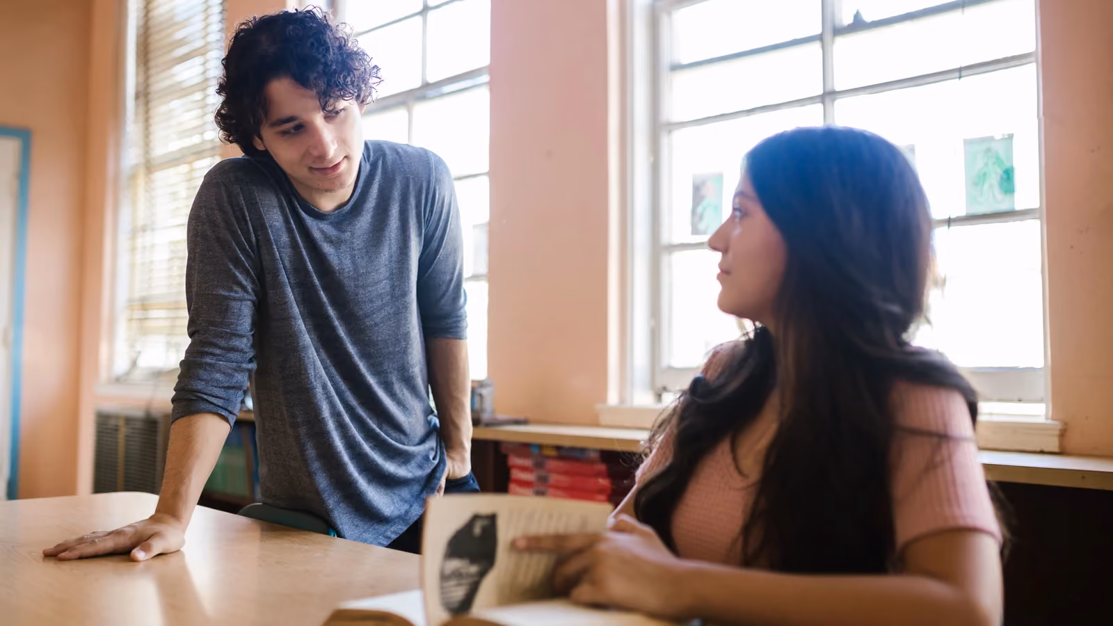 Due giovani adulti discutono in aula, concentrati sui materiali di studio alla scrivania. — RDNE Stock project – Pexels