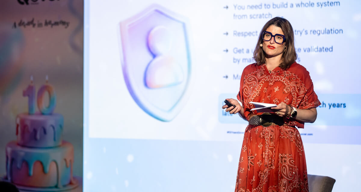 Qover CPO Alix Moggia presenting on stage at Qover's 10-year summit