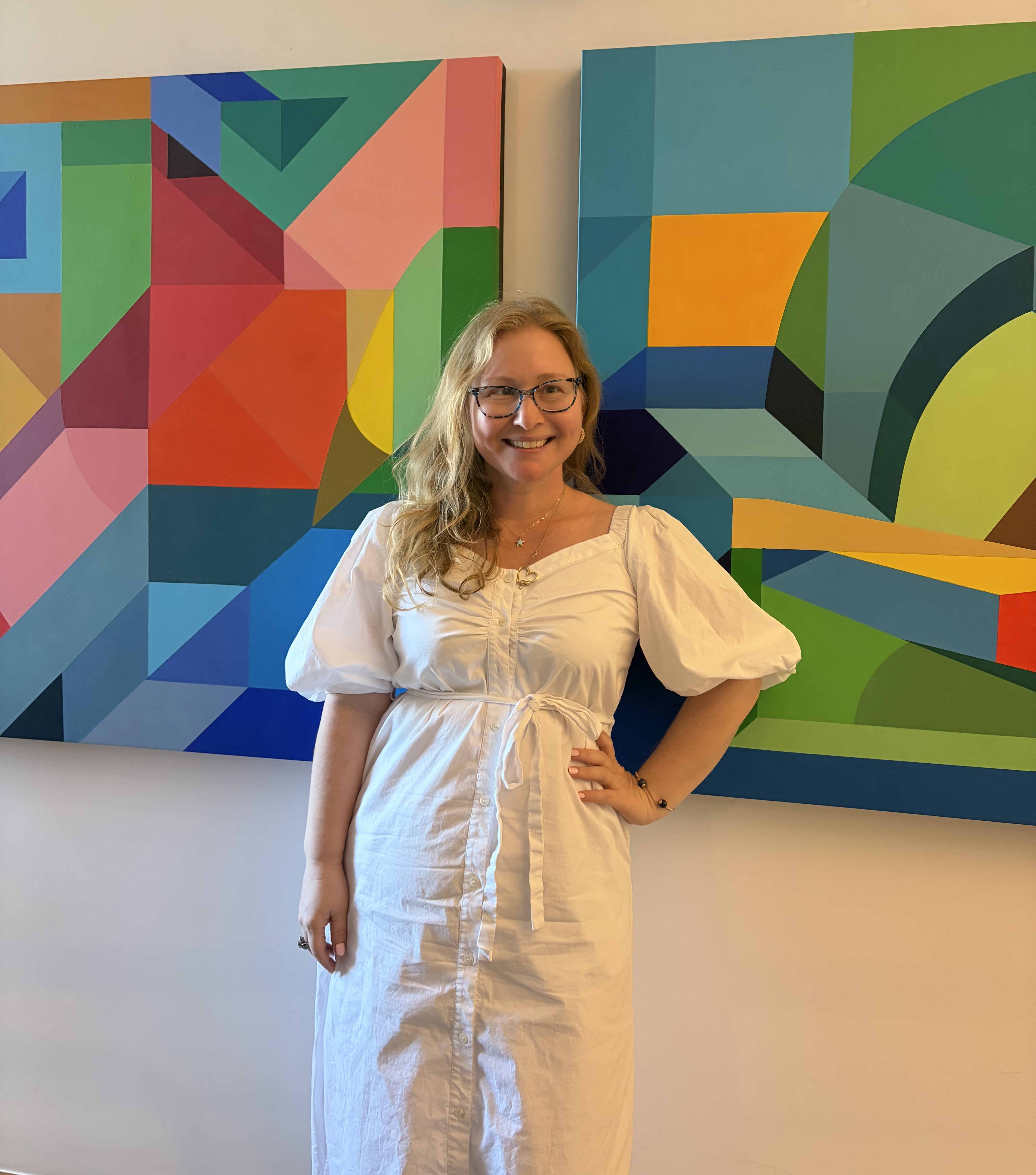Yvethe Blackmore in white dress in front of bright painting