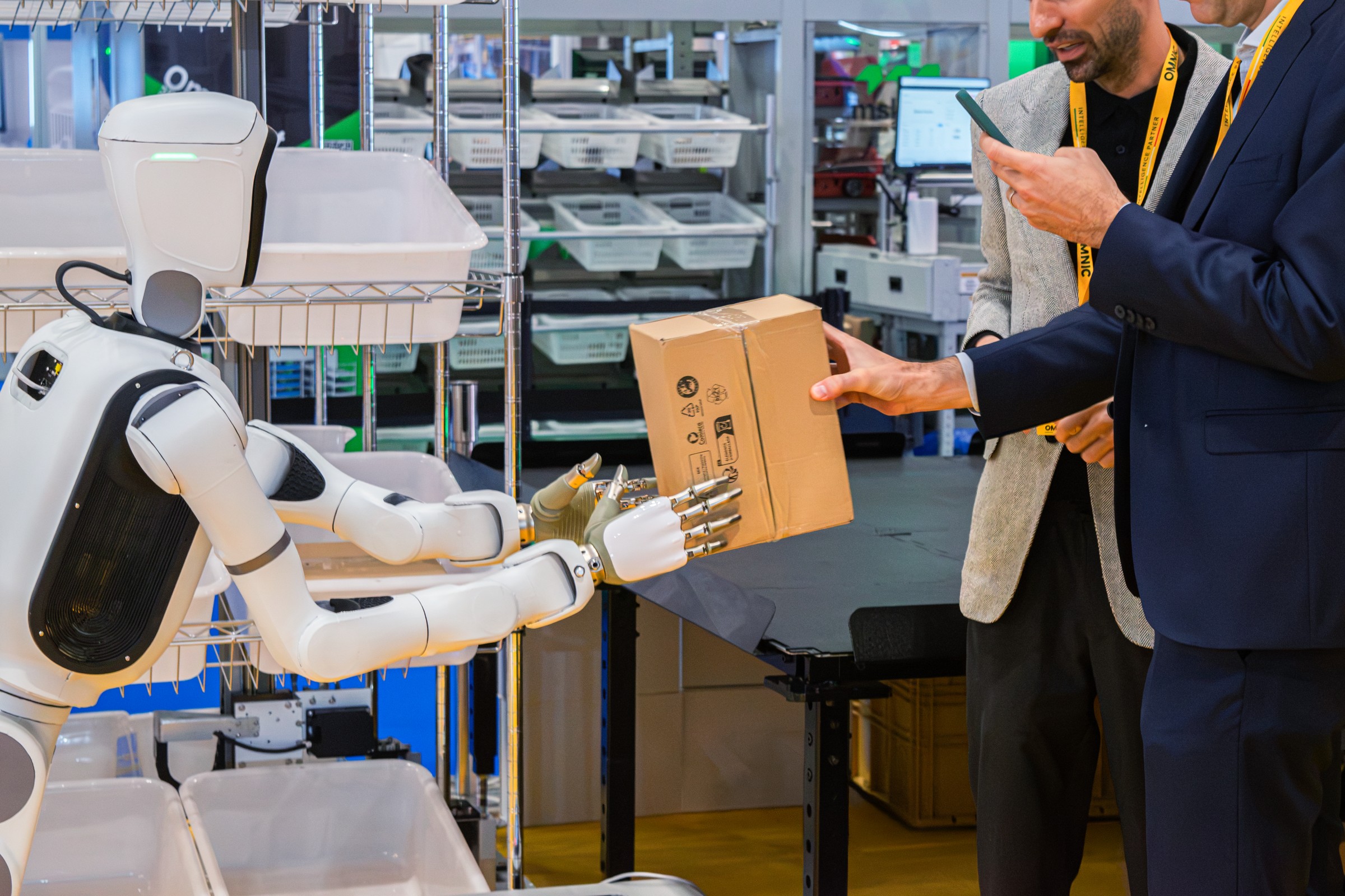 Humanoid robot handing a parcel to visitors at the OMNIC stand