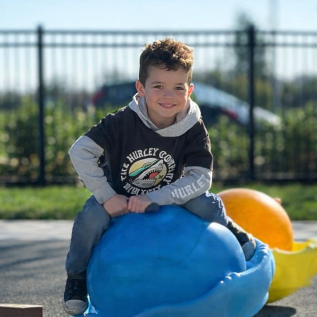 A preschooler playing with a wooden train in a classroom