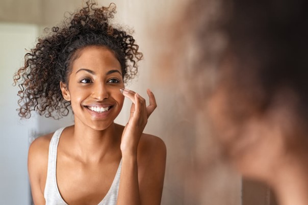 Woman using personalised Q-Stick prescription cream developed through MiQuest AI-powered dermatology