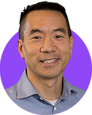 A headshot of a smiling dark haired man in a light blue shirt edited within a simple circle graphic with a bright blue background.