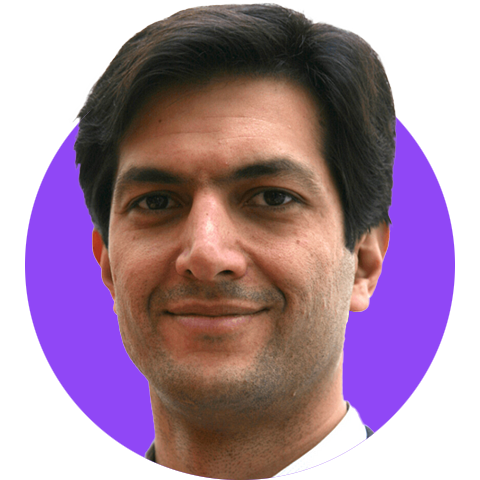 A headshot of a smiling dark haired man and a suit edited within a simple circle graphic with a bright purple background.