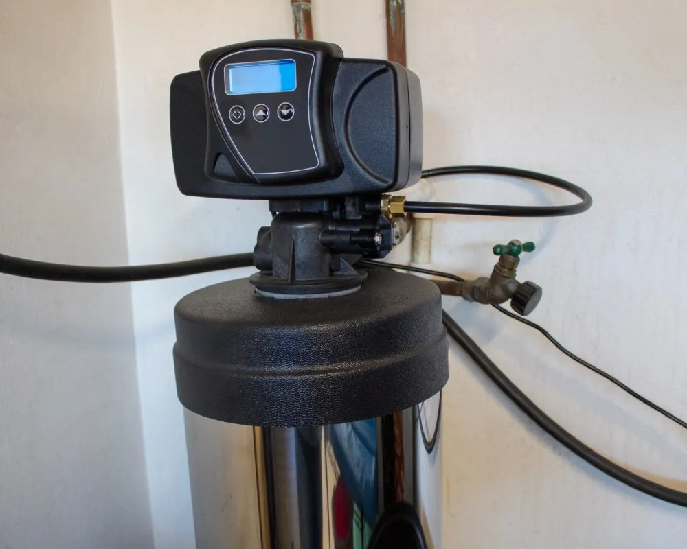 Water softener tank with a digital control head and connected pipes.