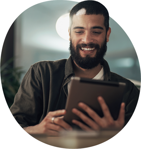 Young professional man smiling and looking at tablet