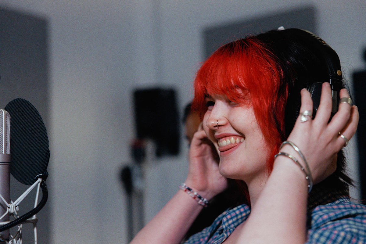 A student smiling wearing headphones