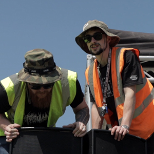 Two students setting up some loud speakers