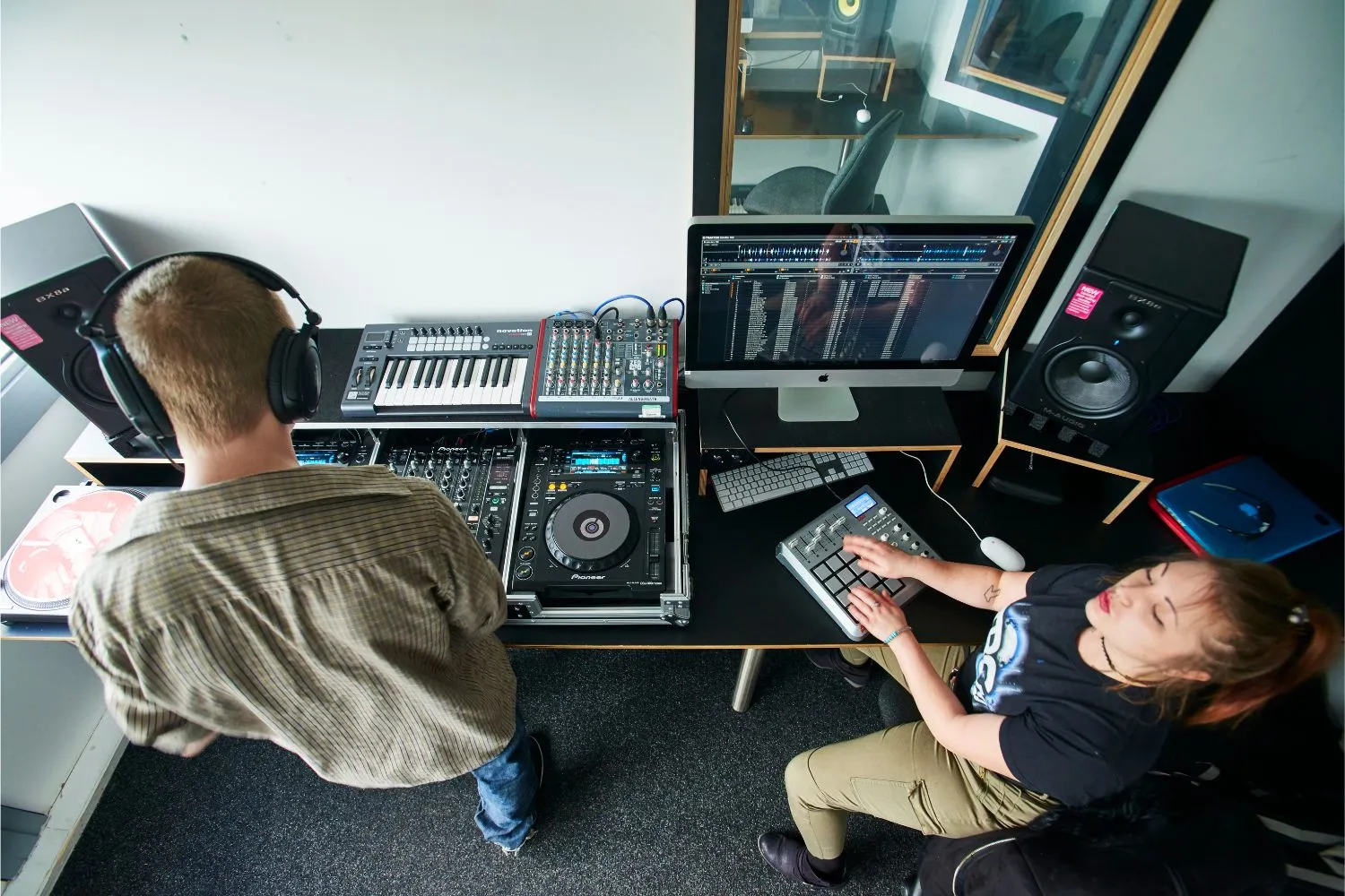 dBs students making music on DJ decks together in the studio, male and female