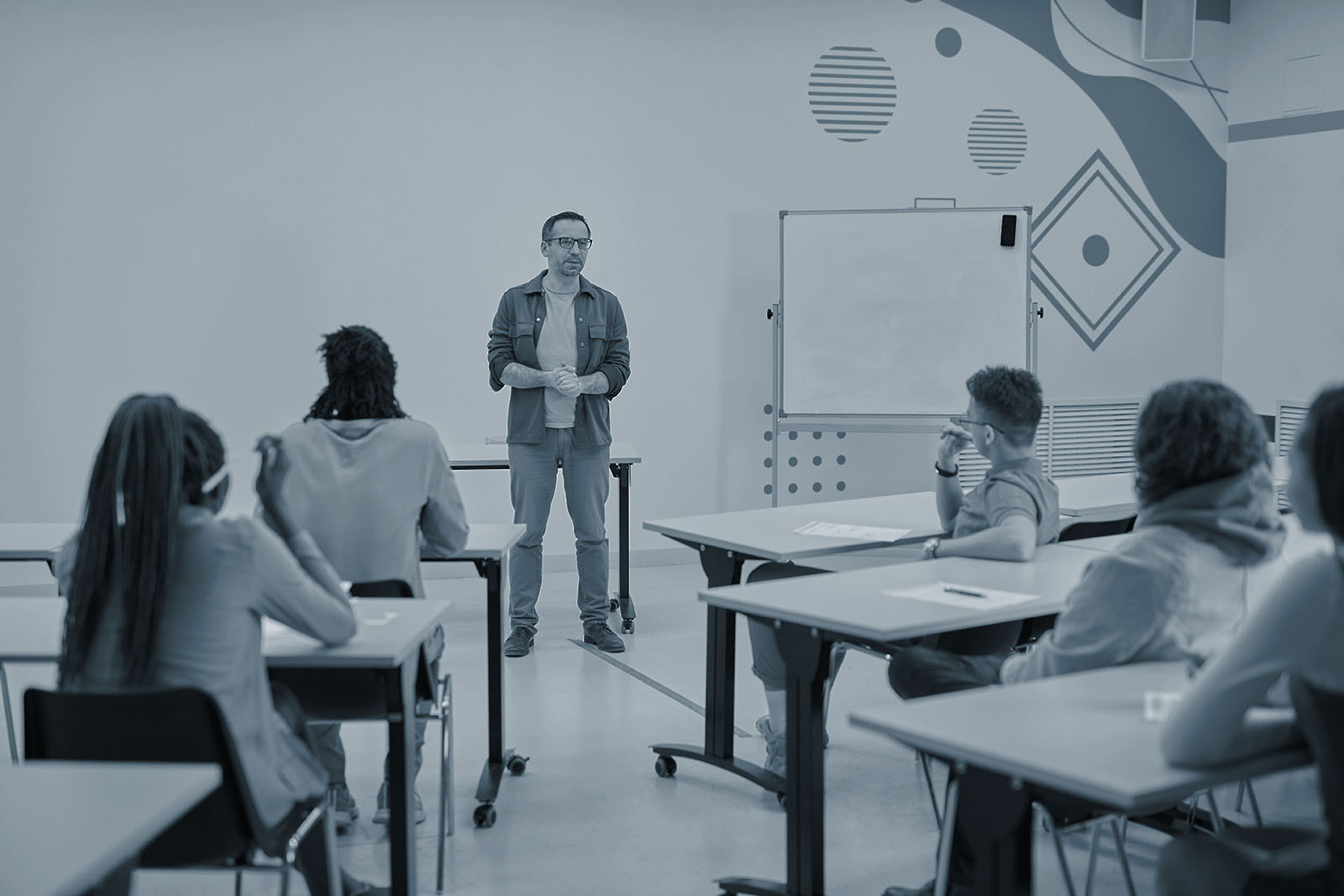 Teacher giving a lecture to students in a classroom, blue duotone