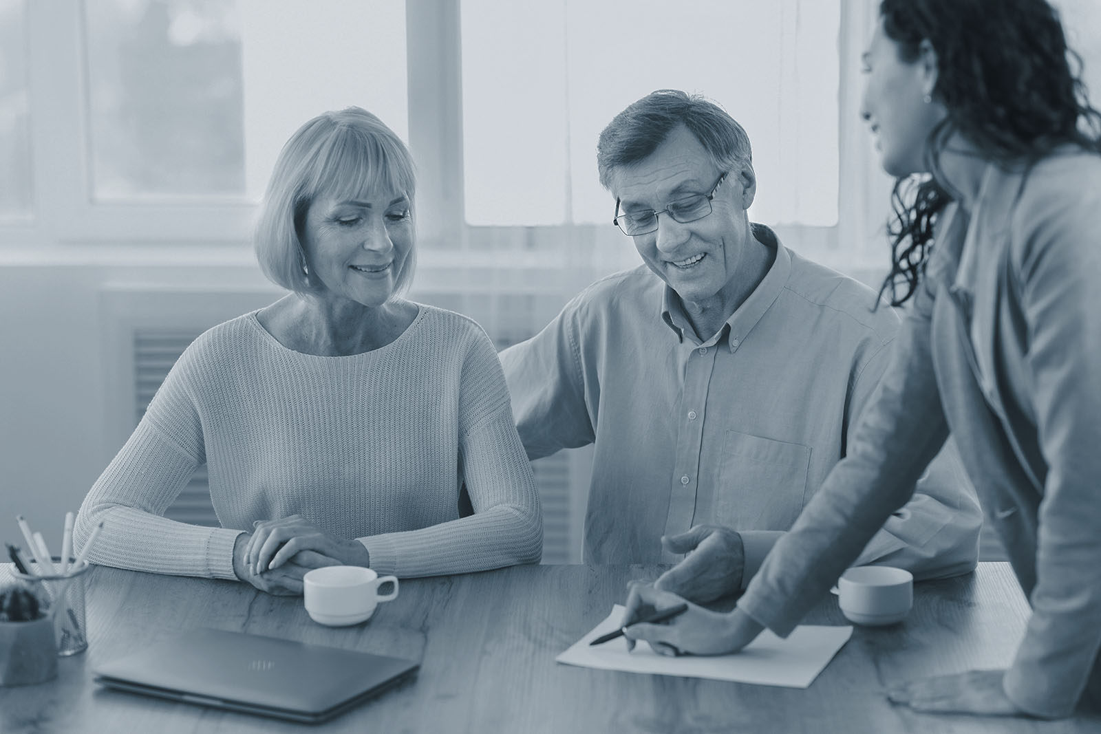 Mature couple reviewing Roth conversion options with their financial advisor, shown in Ignite's blue duotone style