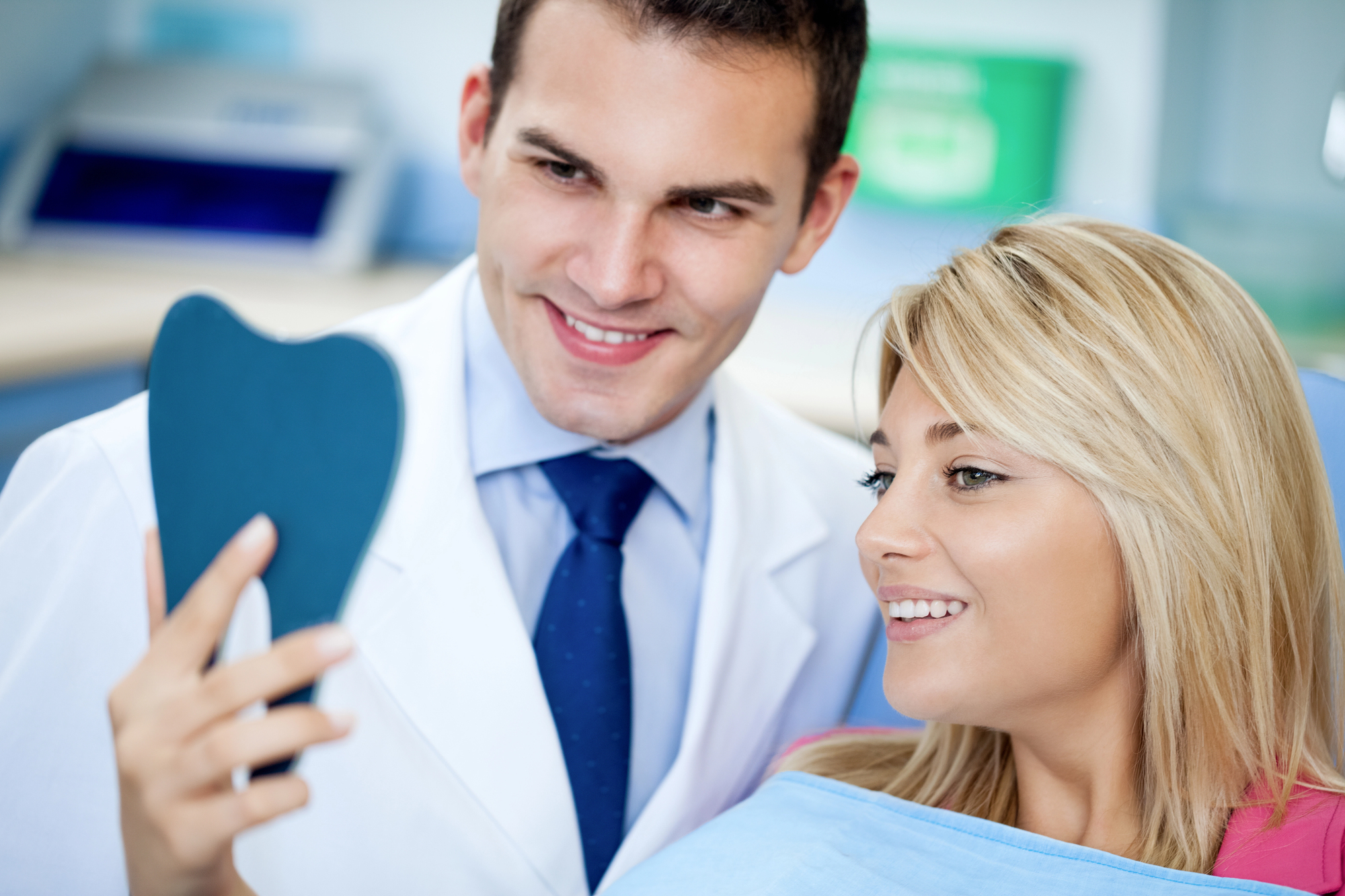 dentist showing woman results from her Teeth Whitening Miramar
