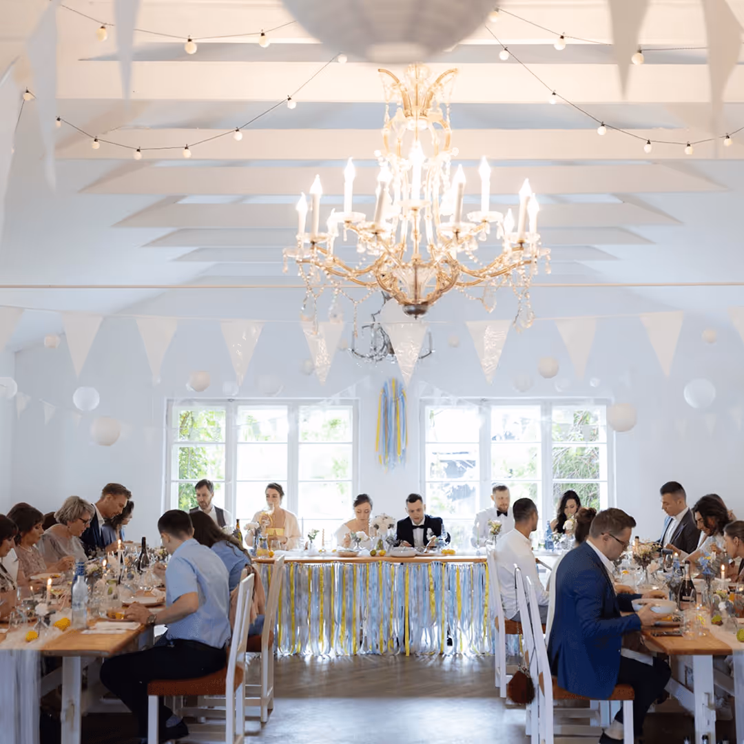 Sala weselna udekorowana przez Be My Flower Wrocław – elegancka przestrzeń z żyrandolem i białymi kwiatami