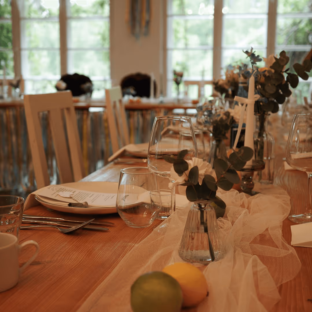 Dekoracja stołu weselnego z zielonymi gałązkami i świecami, aranżacja Be My Flower Wrocław