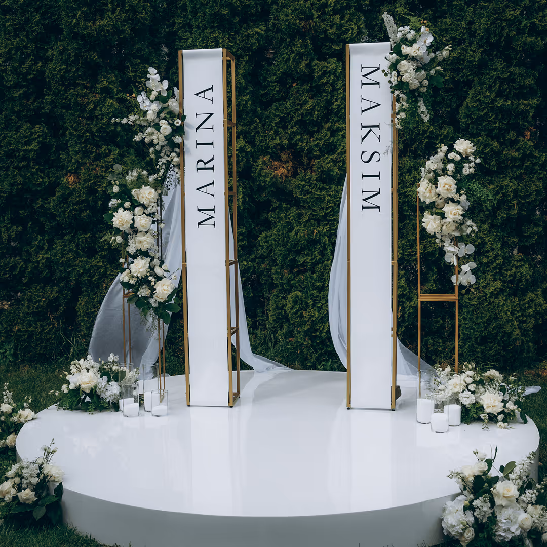 Aranżacja sceny ślubnej z białych kwiatów i eleganckich zasłon, projekt Be My Flower Wrocław