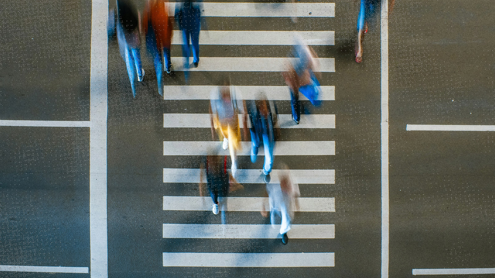 Pedestrians in city crosswalk crossing the road.