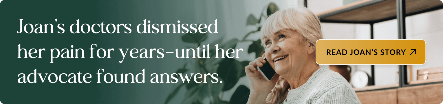 Elderly woman with blonde hair wearing a white sweater, smiling while talking on a phone in a modern living room with plants and shelving in the background. Banner text: Joan's doctors dismissed her pain for years—until her advocate found answers. Includes a button: READ JOAN'S STORY.