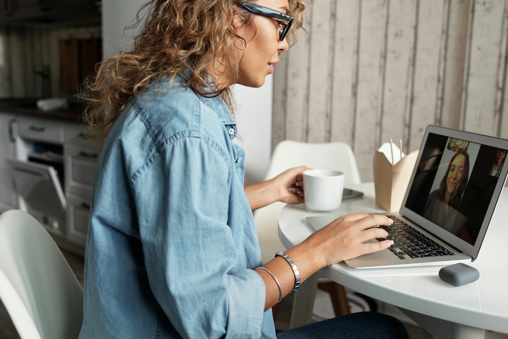 A woman talking to another over a video conference call.